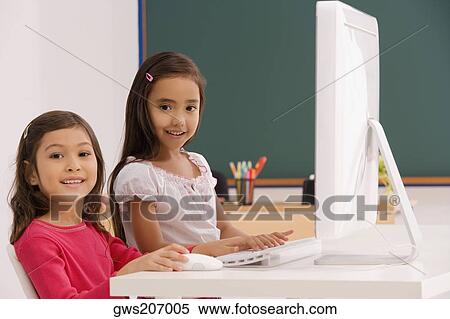 Portrait of two schoolgirls using a computer in a classroom View Large Photo Image Stock Photography - Portrait of two schoolgirls using a computer in a classroom. Fotosearch