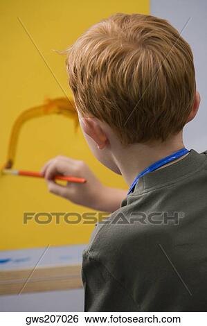 Rear view of a schoolboy painting in an art class View Large Photo Image Stock Photograph - Rear view of a schoolboy painting in an art class. Fotosearch