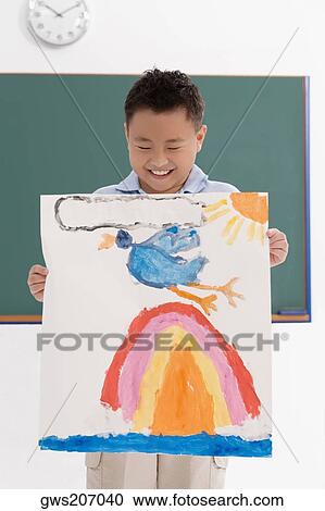 Stock Image - Schoolboy showing his drawing and smiling. Fotosearch