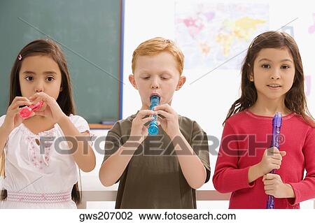 Schoolboy with two schoolgirls playing flutes in a classroom View Large Photo Image Stock Image - Schoolboy with two schoolgirls playing flutes in a classroom. Fotosearch