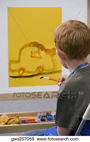 Stock Photo - Side profile of a schoolboy painting in an art class. Fotosearch