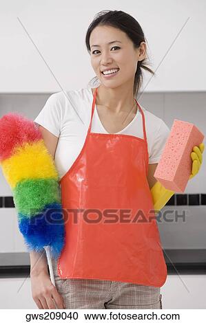 Portrait of a young woman holding a bath sponge and a feather duster View Large Photo Image Stock Image - Portrait of a young woman holding a bath sponge and a feather duster. Fotosearch