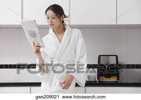 Young woman reading a newspaper View Large Photo Image Stock Image - Young woman reading a newspaper. Fotosearch