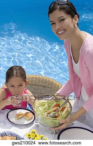 Portrait of a young woman serving breakfast to her daughter View Large Photo Image Picture - Portrait of a young woman serving breakfast to her daughter. Fotosearch
