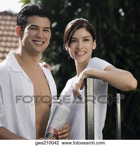 Stock Image - Young couple standing and smiling together. Fotosearch