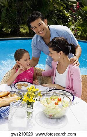 Young couple with their daughter at a breakfast table View Large Photo Image Stock Image - Young couple with their daughter at a breakfast table. Fotosearch