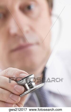 Stock Photo - Close-up of a male doctor holding a stethoscope. Fotosearch