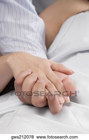 Close-up of a man's hand holding a female patient's hand View Large Photo Image Stock Photo - Close-up of a man's hand holding a female patient's hand. Fotosearch