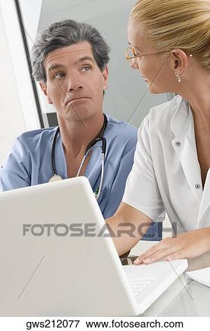 Female doctor discussing with a male surgeon View Large Photo Image Stock Photo - Female doctor discussing with a male surgeon. Fotosearch