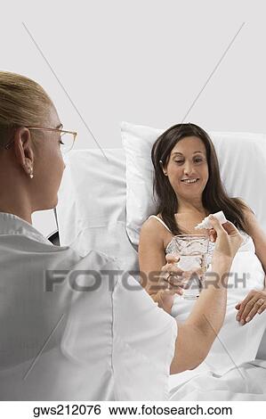 Female doctor giving medicine to a mature woman View Large Photo Image Stock Photograph - Female doctor giving medicine to a mature woman. Fotosearch