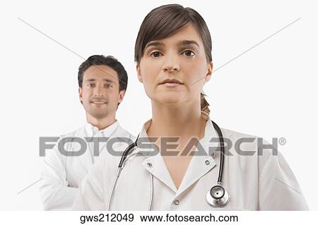 Female doctor thinking with a male doctor smiling behind her View Large Photo Image Stock Photo - Female doctor thinking with a male doctor smiling behind her. Fotosearch