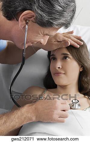 High angle view of a male doctor examining a young woman View Large Photo Image Stock Image - High angle view of a male doctor examining a young woman. Fotosearch