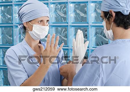 Male surgeon adjusting a surgical glove of a female surgeon View Large Photo Image Stock Photo - Male surgeon adjusting a surgical glove of a female surgeon. Fotosearch