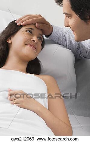 Mid adult man touching a young woman's head View Large Photo Image Stock Photo - Mid adult man touching a young woman's head. Fotosearch