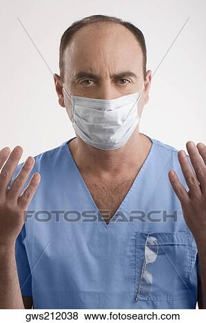 Stock Photo - Portrait of a male surgeon with his arms raised. Fotosearch