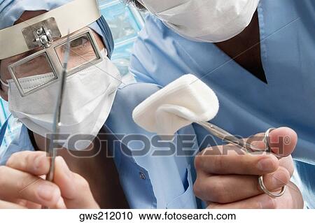 Two surgeons holding surgical scissors View Large Photo Image Stock Image - Two surgeons holding surgical scissors. Fotosearch