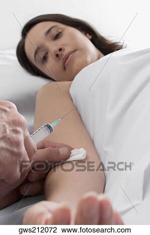 Young woman getting an injection on her hand View Large Photo Image Stock Image - Young woman getting an injection on her hand. Fotosearch