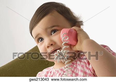 Close-up of a girl playing with a toy phone View Large Photo Image Stock Image - Close-up of a girl playing with a toy phone. Fotosearch