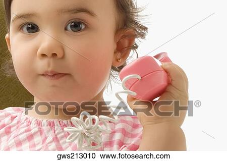 Stock Image - Portrait of a girl using a toy phone. Fotosearch