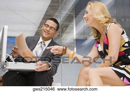 Businessman showing a document to a mature woman sitting beside him View Large Photo Image Stock Photograph - Businessman showing a document to a mature woman sitting beside him. Fotosearch