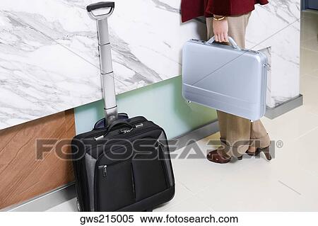 Low section view of a woman holding a briefcase View Large Photo Image Stock Photography - Low section view of a woman holding a briefcase. Fotosearch