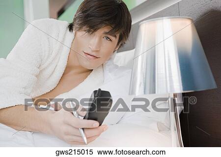 Portrait of a young man holding a telephone receiver View Large Photo Image Stock Photography - Portrait of a young man holding a telephone receiver. Fotosearch
