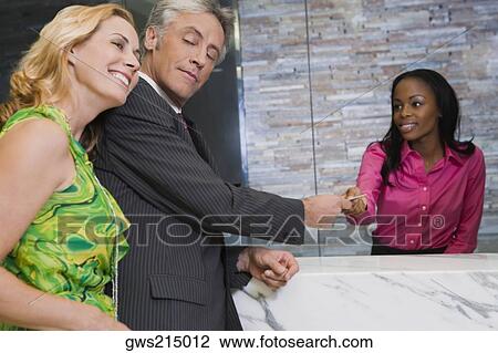 Receptionist giving the cardkey to a customer View Large Photo Image Stock Image - Receptionist giving the cardkey to a customer. Fotosearch