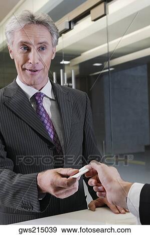 Receptionist giving the cardkey to a customer View Large Photo Image Stock Photo - Receptionist giving the cardkey to a customer. Fotosearch