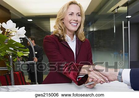 Receptionist giving the cardkey to a customer View Large Photo Image Stock Photograph - Receptionist giving the cardkey to a customer. Fotosearch