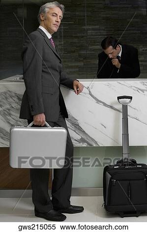 Stock Photography - Side profile of a mature man standing at the reception. Fotosearch