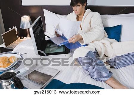 Young man examining documents View Large Photo Image Stock Image - Young man examining documents. Fotosearch