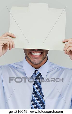 Close-up of a businessman holding a placard in front of his face View Large Photo Image Stock Photo - Close-up of a businessman holding a placard in front of his face. Fotosearch