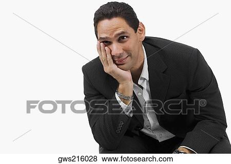 Close-up of a businessman sitting with his hand on his chin View Large Photo Image Stock Photo - Close-up of a businessman sitting with his hand on his chin. Fotosearch
