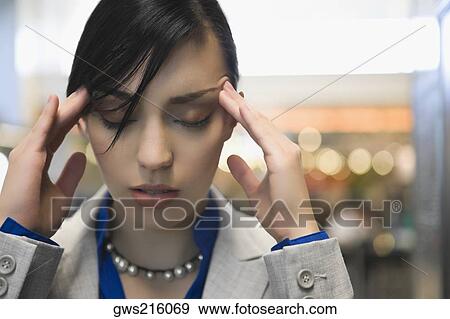 Stock Photo - Close-up of a businesswoman suffering from a headache. Fotosearch