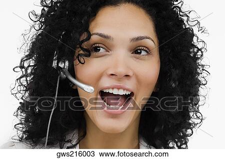 Stock Image - Close-up of a female customer service representative wearing a headset. Fotosearch