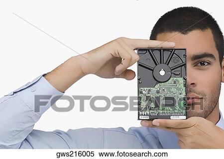Portrait of a businessman holding a hard drive in front of his face View Large Photo Image Stock Photography - Portrait of a businessman holding a hard drive in front of his face. Fotosearch