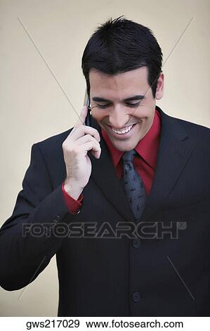 Businessman talking on a mobile phone and smiling View Large Photo Image Stock Photo - Businessman talking on a mobile phone and smiling. Fotosearch