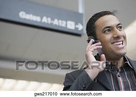 Close-up of a businessman laughing in a hands free device at an airport View Large Photo Image Stock Image - Close-up of a businessman laughing in a hands free device at an airport. Fotosearch