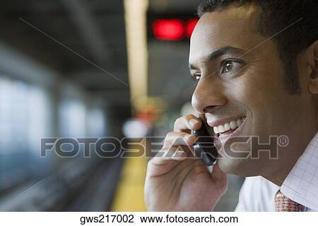 Close-up of a businessman talking on a mobile phone at a subway station View Large Photo Image Stock Image - Close-up of a businessman talking on a mobile phone at a subway station. Fotosearch