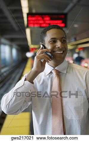 Close-up of a businessman talking on a mobile phone at a subway station View Large Photo Image Stock Image - Close-up of a businessman talking on a mobile phone at a subway station. Fotosearch