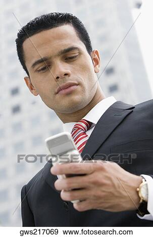 Close-up of a businessman text messaging View Large Photo Image Stock Photo - Close-up of a businessman text messaging. Fotosearch