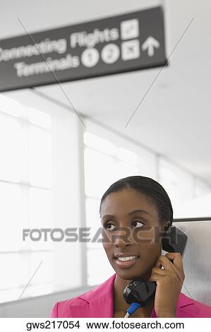 Close-up of a businesswoman talking on a pay phone and smiling View Large Photo Image Picture - Close-up of a businesswoman talking on a pay phone and smiling. Fotosearch
