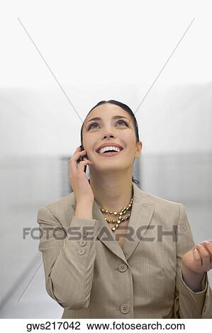 Close-up of a businesswoman talking on a mobile phone and smiling View Large Photo Image Stock Image - Close-up of a businesswoman talking on a mobile phone and smiling. Fotosearch