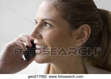 Close-up of a businesswoman talking on a mobile phone and smiling View Large Photo Image Stock Image - Close-up of a businesswoman talking on a mobile phone and smiling. Fotosearch