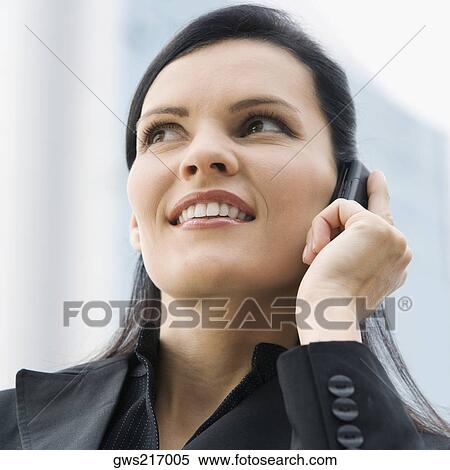 Close-up of a businesswoman talking on a mobile phone and smiling View Large Photo Image Stock Photography - Close-up of a businesswoman talking on a mobile phone and smiling. Fotosearch