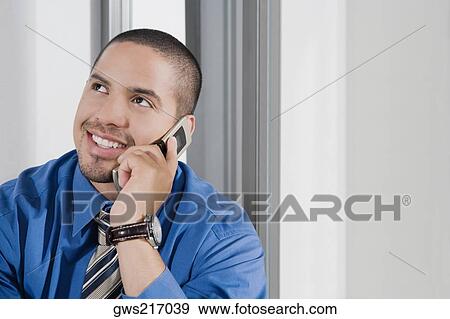 Stock Photo - Close-up of a mid adult man talking on a mobile phone. Fotosearch
