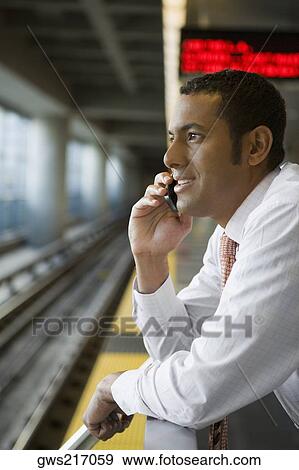 Side profile of a businessman talking on a mobile phone at a subway station View Large Photo Image Stock Photo - Side profile of a businessman talking on a mobile phone at a subway station. Fotosearch