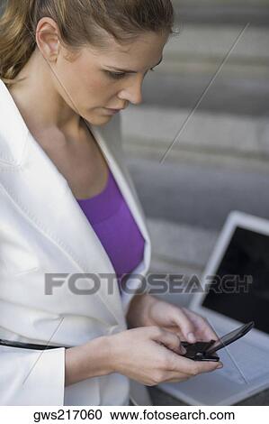 Side profile of a businesswoman operating a mobile phone View Large Photo Image Stock Image - Side profile of a businesswoman operating a mobile phone. Fotosearch