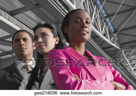 Low angle view of two businesswomen with a businessman at an airport View Large Photo Image Stock Photograph - Low angle view of two businesswomen with a businessman at an airport. Fotosearch