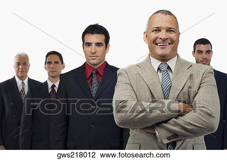 Stock Image - Portrait of a businessman smiling with four businessmen standing behind him. Fotosearch